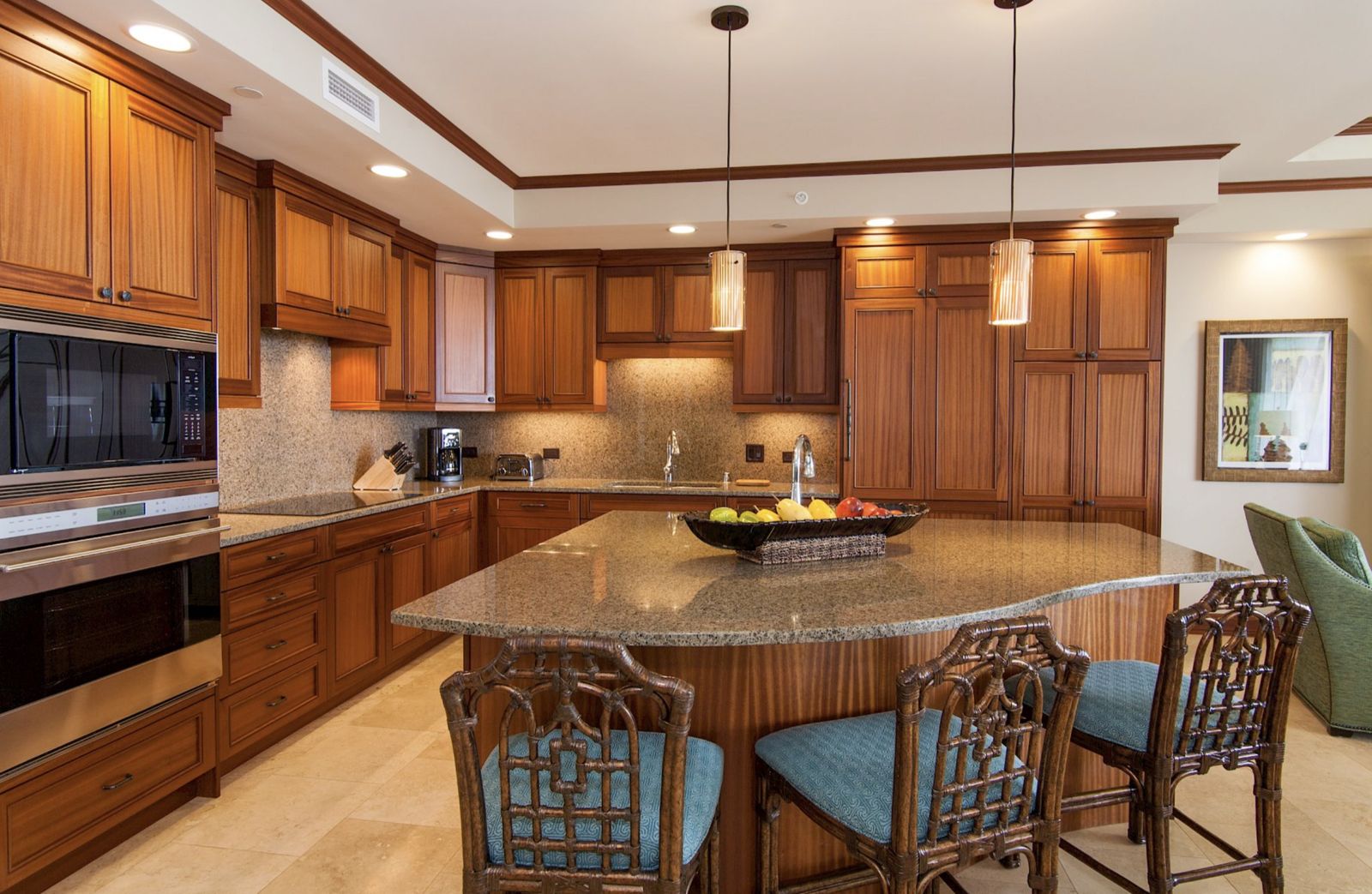 Full casita kitchen with a granite island, bar seating, and rich koa-toned cabinets